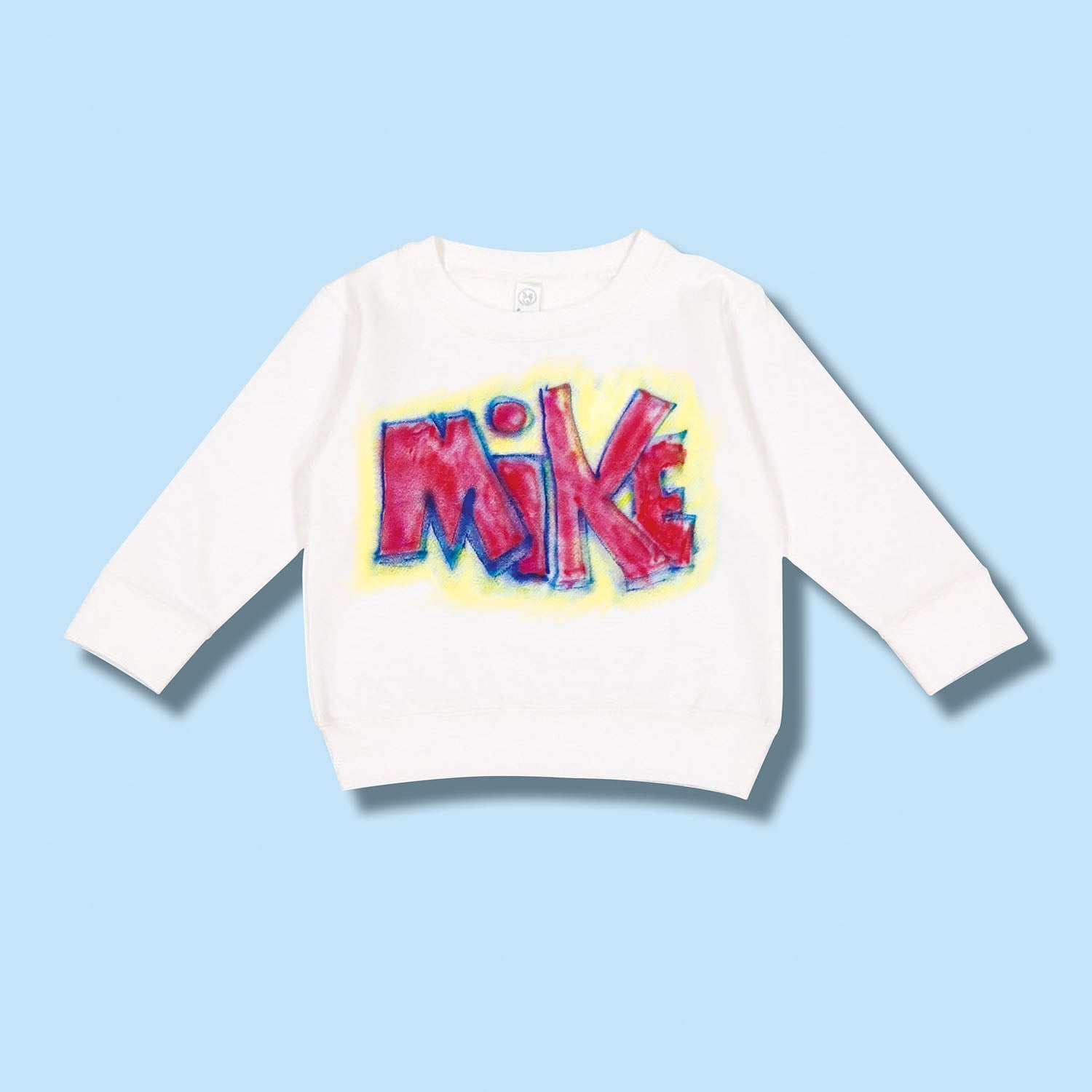 White long-sleeve shirt with colorful 'MIKE' print on a light blue background