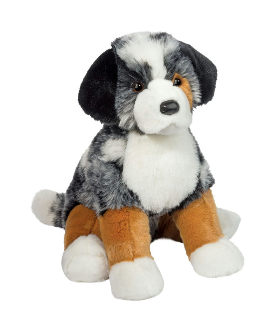 Plush toy dog with black, white, and brown fur on a white background