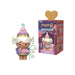A TOMY Momiji message doll figure with a pink and purple mushroom-shaped hat, white hair, and a small green hanging toy, shown next to its illustrated retail box on a plain white background.