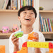 Child playing with colorful building blocks in a room with bookshelves.