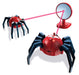 A red and black spider-shaped toy with a dome-shaped head and multiple articulated legs, shown alongside a red stand with a circular mirror and a pink laser beam connecting the two. The background is solid white.