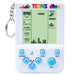 A retro-style Tetris handheld game console with a keychain ring and metal chain, shown on a plain white background. The device has a white plastic body, a light green screen with black game graphics and text, colorful Tetris logo at the top, and five blue buttons on the front.