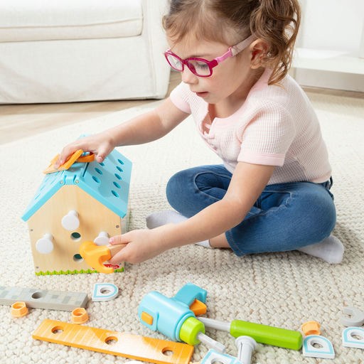 Child playing with colorful building blocks on a carpeted floor