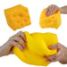 Three views of a yellow cheese-shaped squishy toy on a white background: one whole view, one being pressed, and one being stretched by hands.