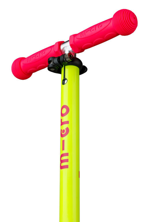 A close-up of a Micro brand kick scooter handlebar and stem. The handlebars are bright hot pink with textured grips, and the stem is a vibrant neon yellow-green with the brand name 'micro' printed vertically in pink.
