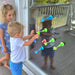 Two children playing with colorful toys on a glass door.