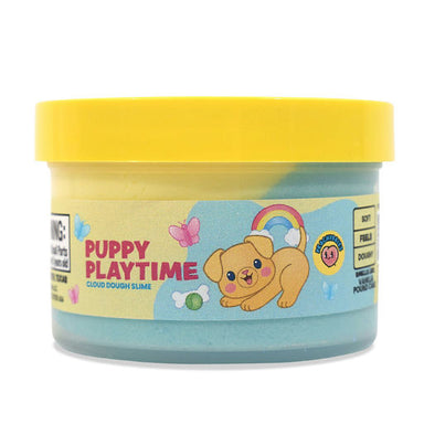 A jar of Puppy Playtime Cloud Dough Slime by Sweet Tooth Slime Co. The product is a light blue slime with a bright yellow lid and a colorful label featuring a cartoon puppy, rainbow, and butterflies.
