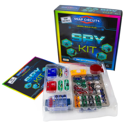 A toy electronics kit called 'Top Secret Snap Circuits Spy Kit' shown with its colorful retail box, instruction booklet, and a clear plastic tray containing various colorful electronic components and small circuit boards on a white background.