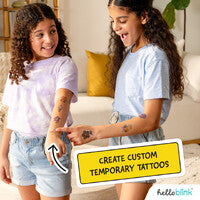 Two children with temporary tattoos, one applying a tattoo to the other's arm, with 'Create Custom Temporary Tattoos' text overlay.